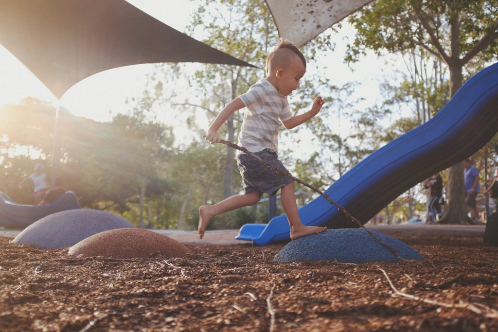 a small boy running through a playground