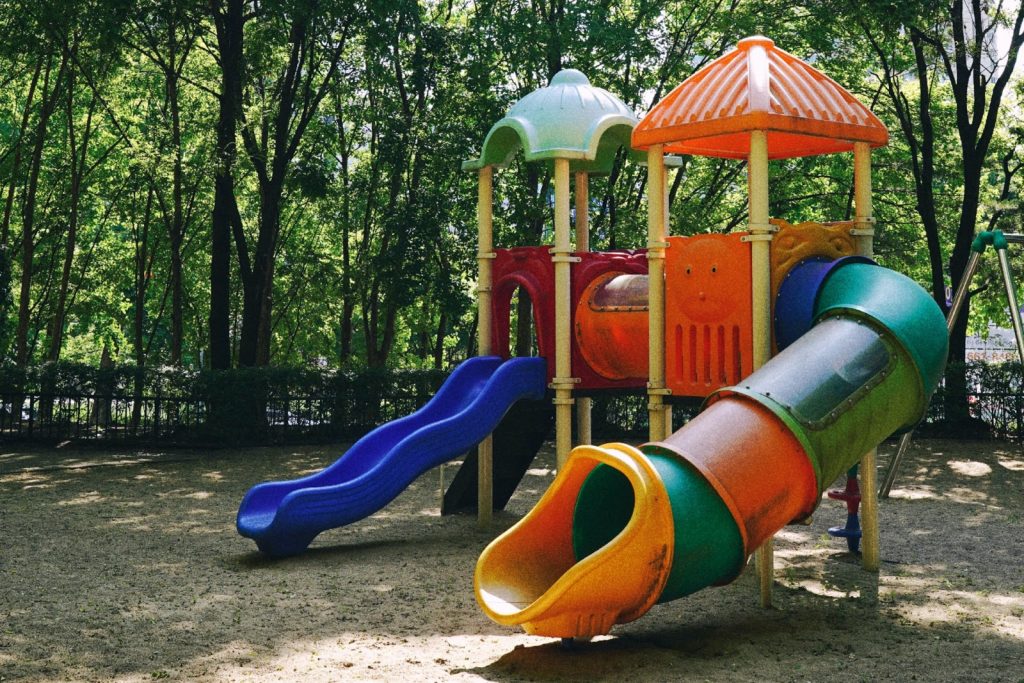 a playground with a tube slide and an open slide