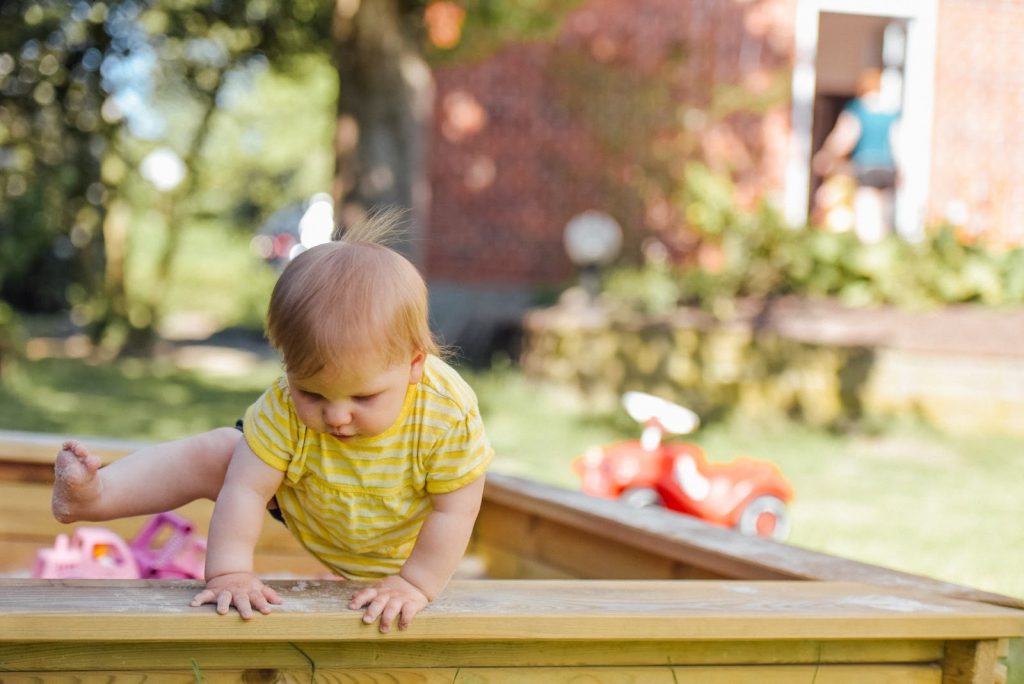 toddler playing in a sandbox