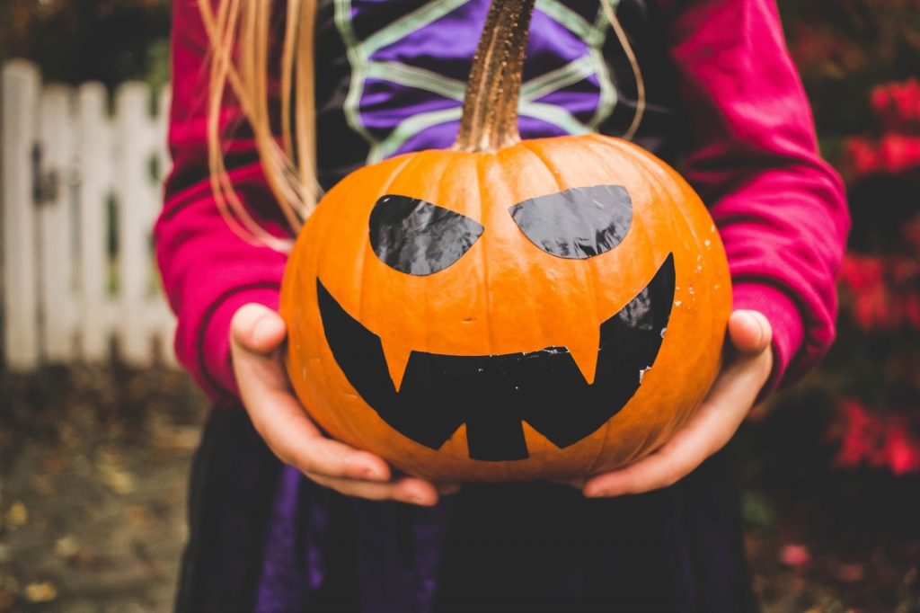 a young girl holding a pumpkin