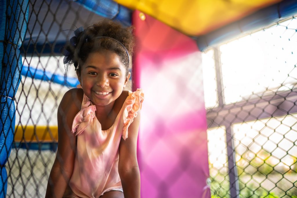 a young girl inside a play space smiling