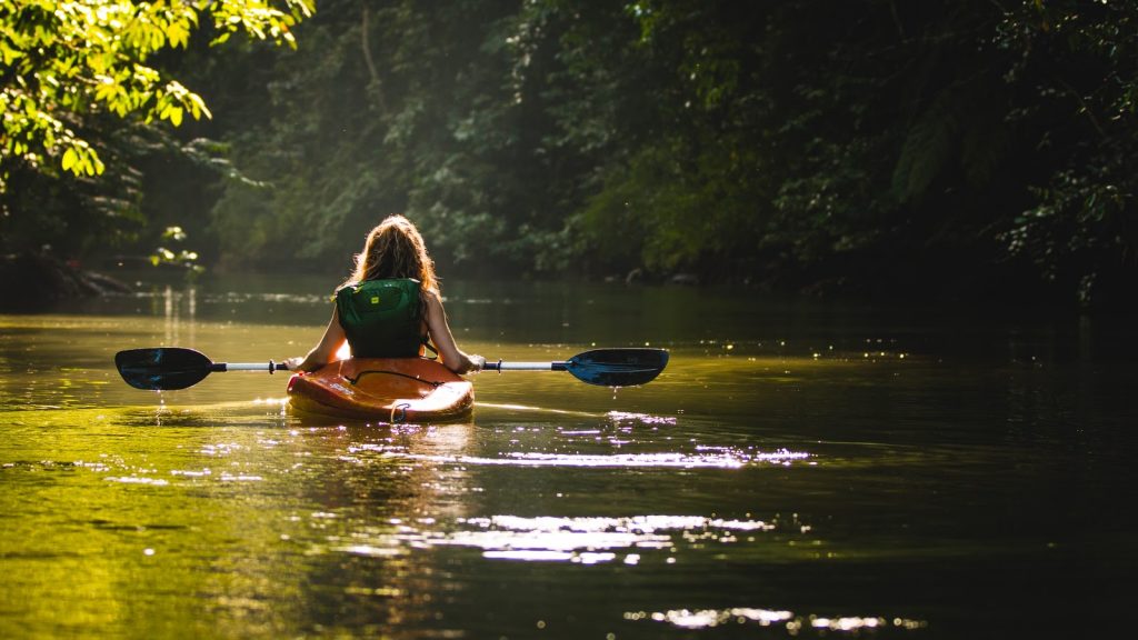 a woman kayaking down a river