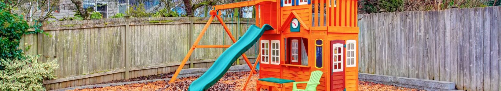 A small plastic playground in a backyard.