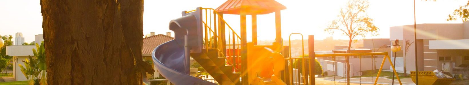 A outdoor playground with two slides and a swingset.
