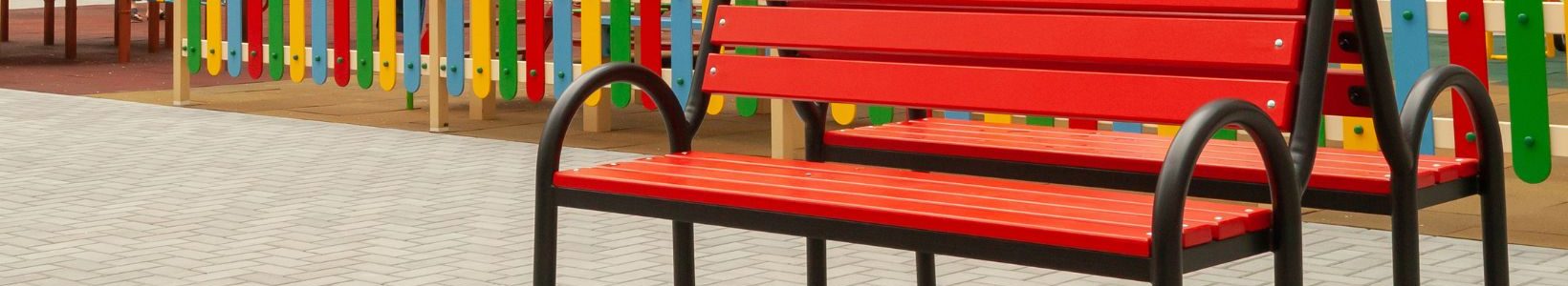 An outdoor park with a fence wrapped around it and two benches.