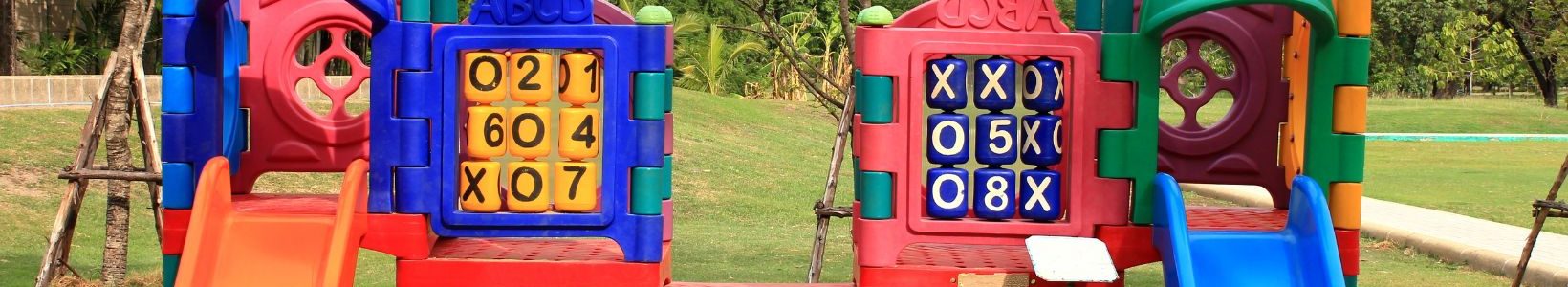 An outdoor playground that has slides and activity panels.