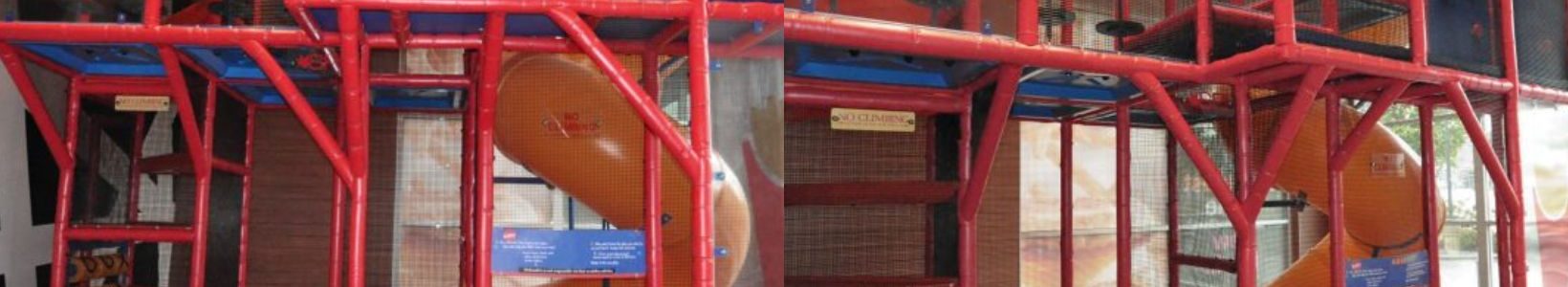 Indoor playground with a red climbing structure, blue panels, and an orange slide. The bright setup suggests a fun and active play area for kids.